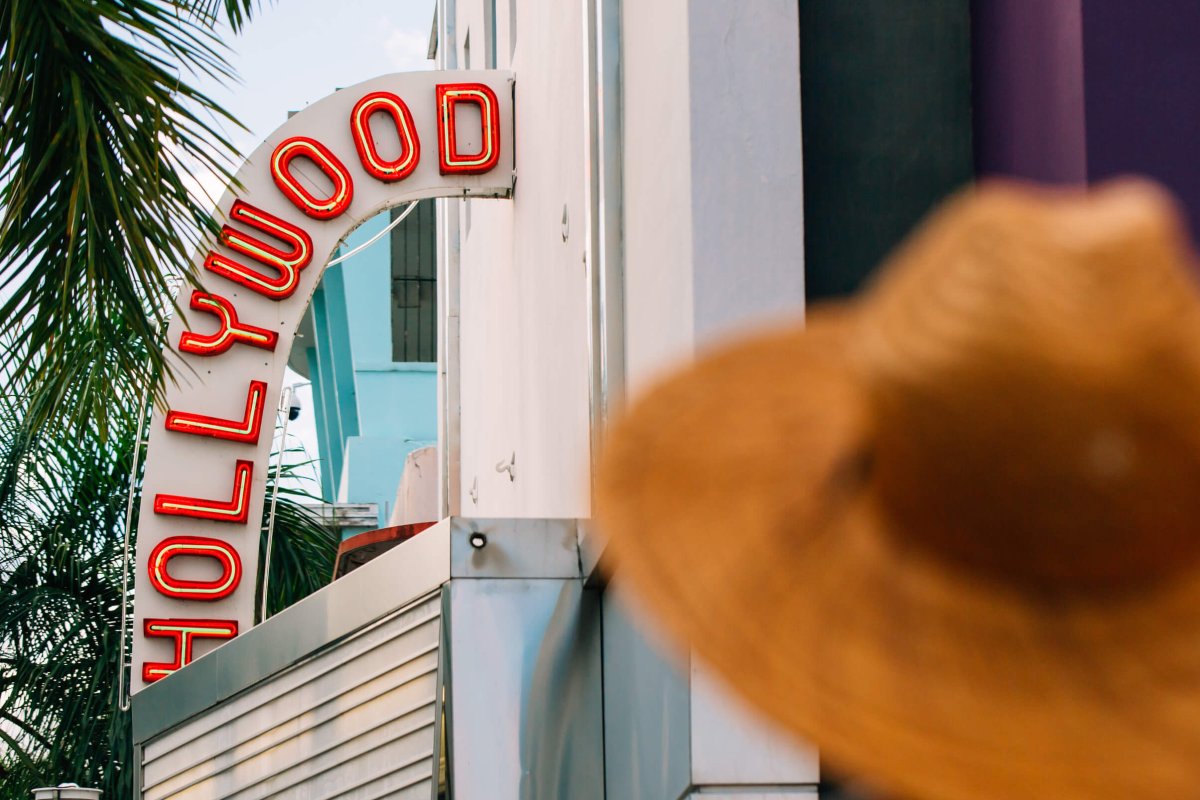 Woman in a hat standing outside the historic Hollywood Theater in Coamo. 