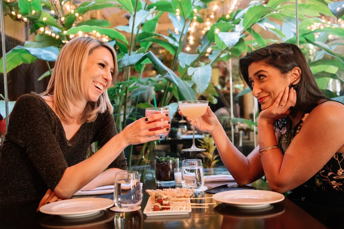 A couple enjoys craft cocktails while dining