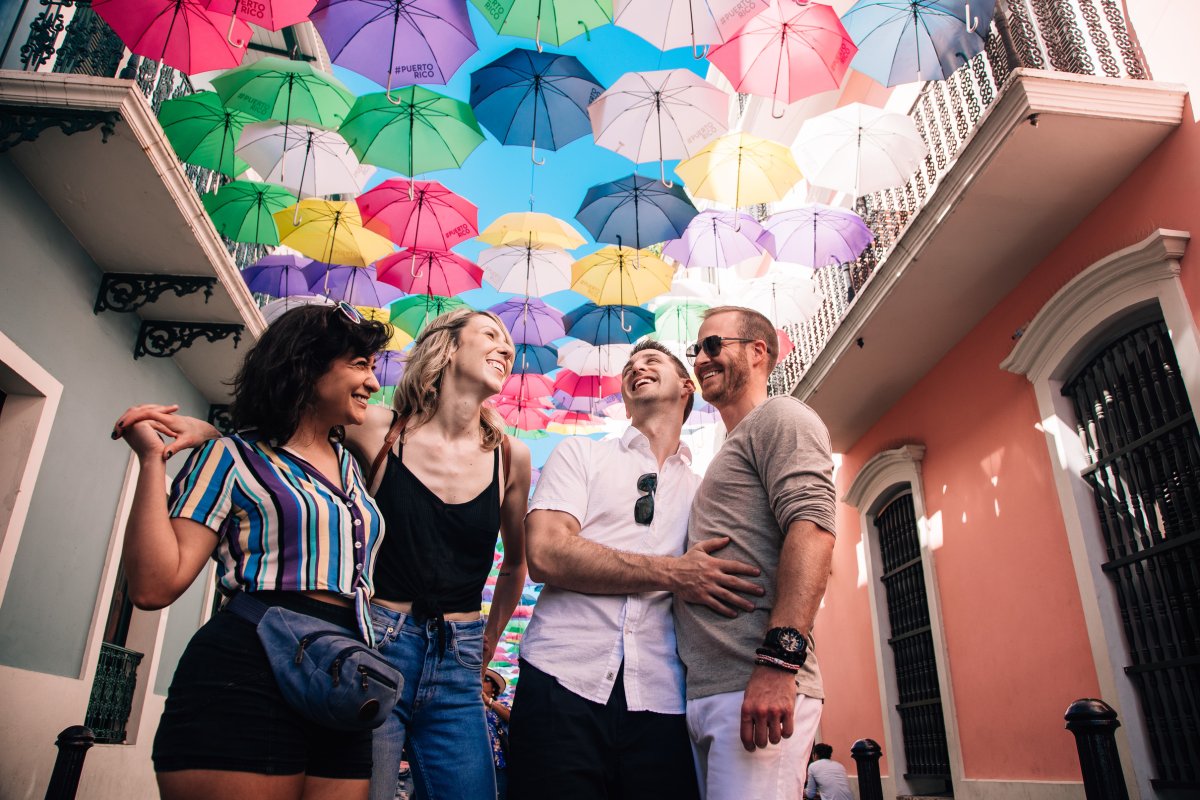 Two couples laugh on the street in old san juan.