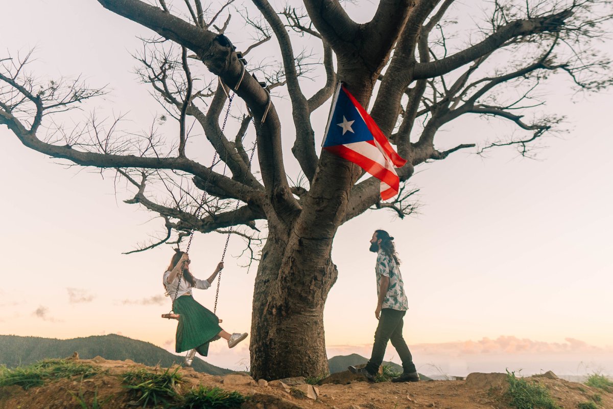 A couple enjoys the outdoors on top of a mountain.