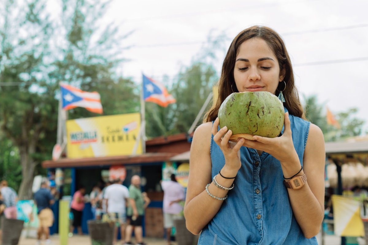 Girl drinks coconut water at Piñones.