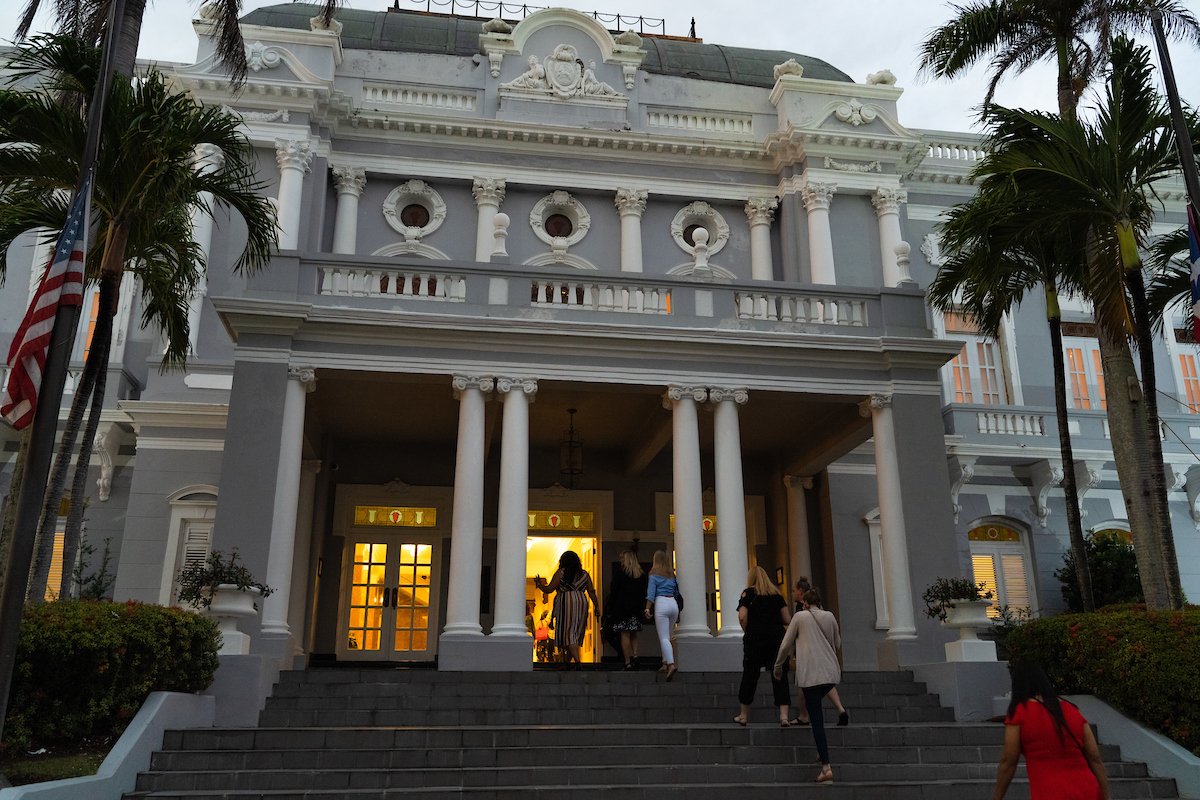 A group of people enter the Antiguo Casino of Puerto Rico for an event. 