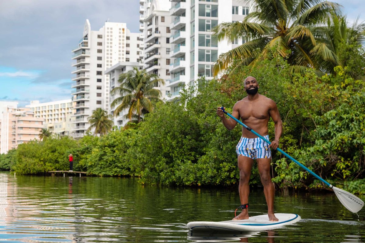 A man stand-up paddleboards on Condado Lagoon in San Juan, Puerto Rico.