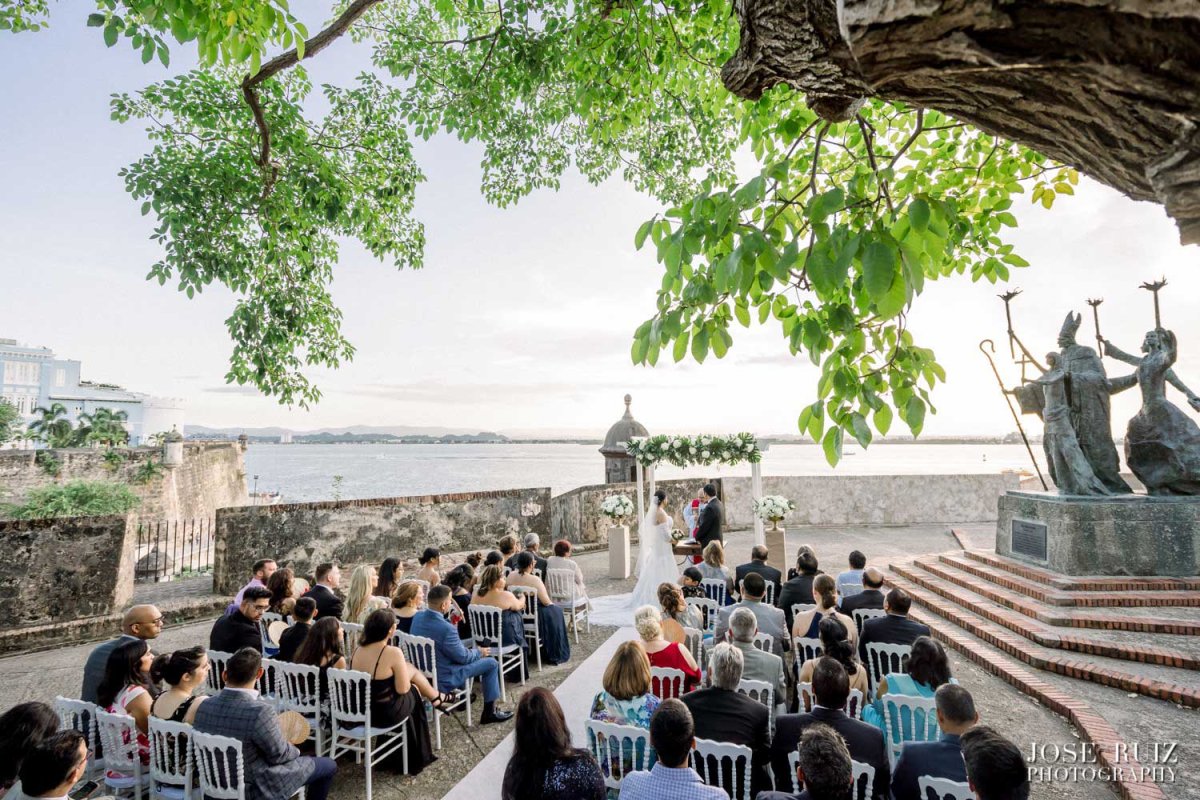 Guests seated for a wedding in front of the iconic La Rogativa statue in Old San Juan.