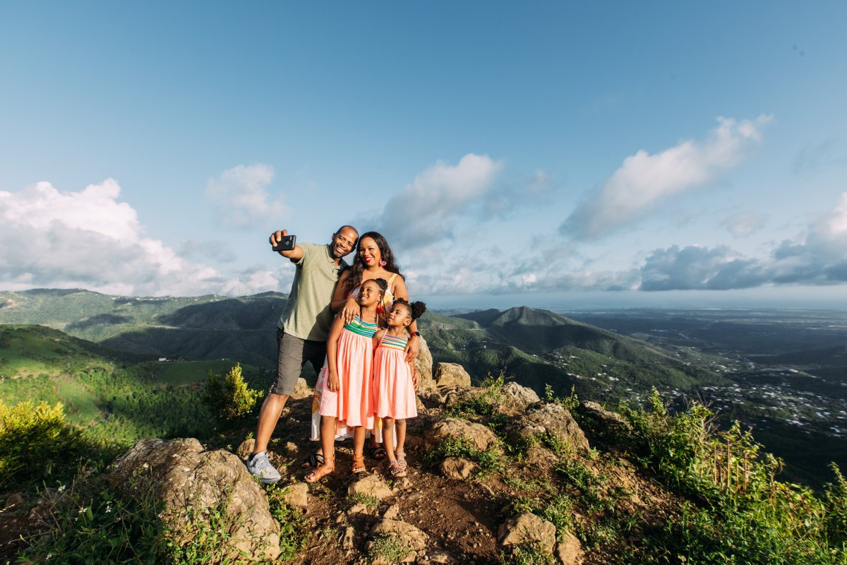 A family poses for a selfie during a hike. 