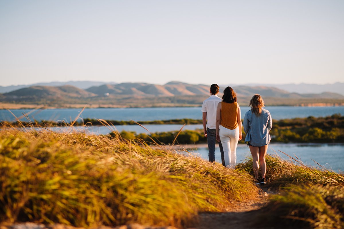 Family of three hiking along the coastline at Cabo Rojo National Forest.