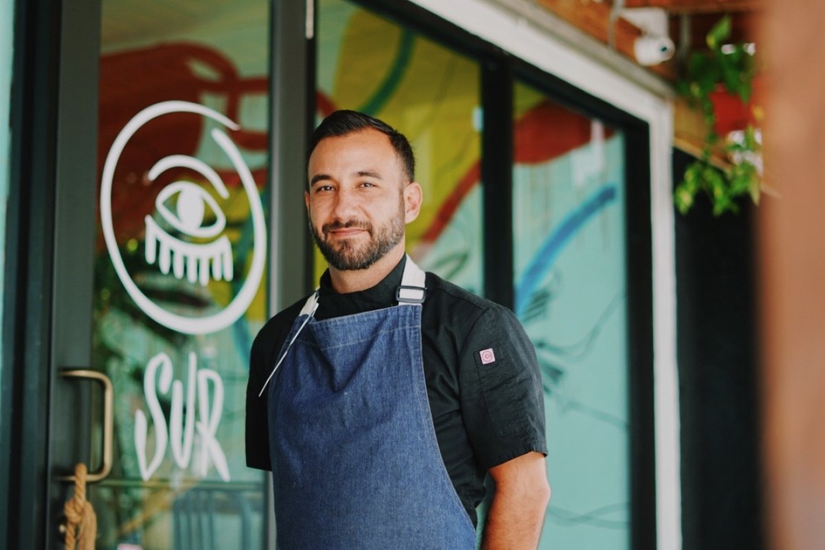 Chef Rafael Ubior posesin front of his restaurant SUR Barra Nikkei