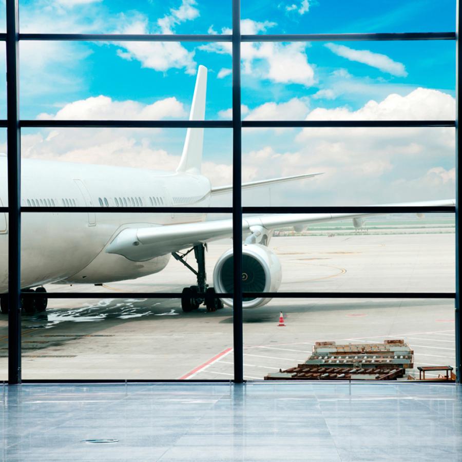 An airplane on runway viewed through the windows from the inside of the airport in San Juan.