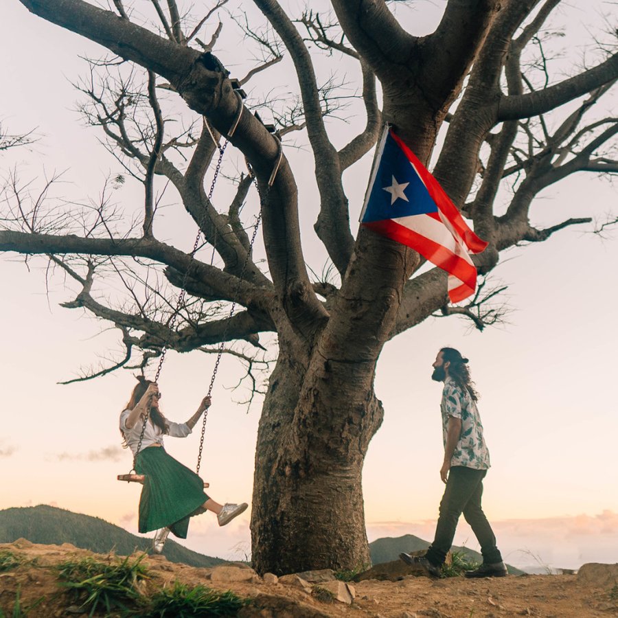 A couple enjoys the outdoors on top of a mountain.