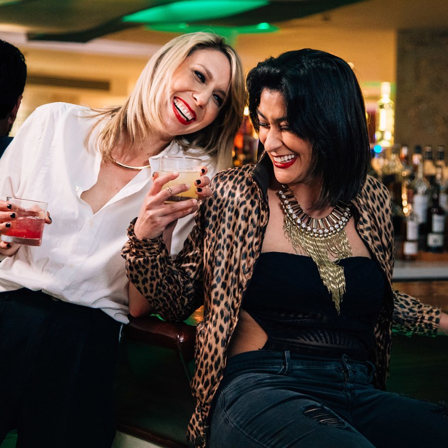 A couple of lesbians enjoying their cocktails at a bar.