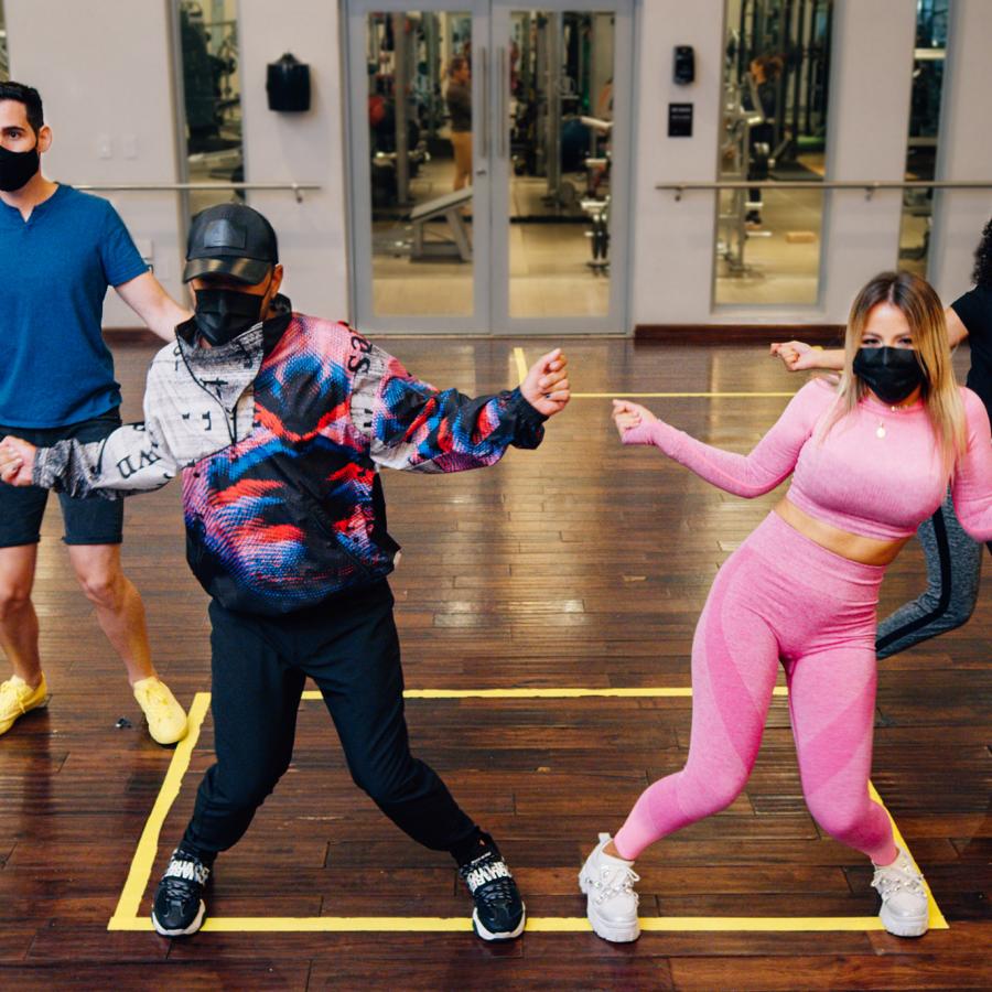 A group of young people learning to dance reggaeton.