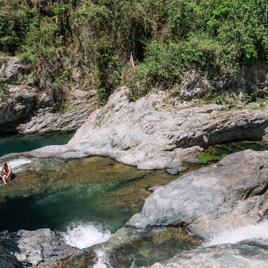 A group of people enjoy a day at the river El Ataud in Adjuntas