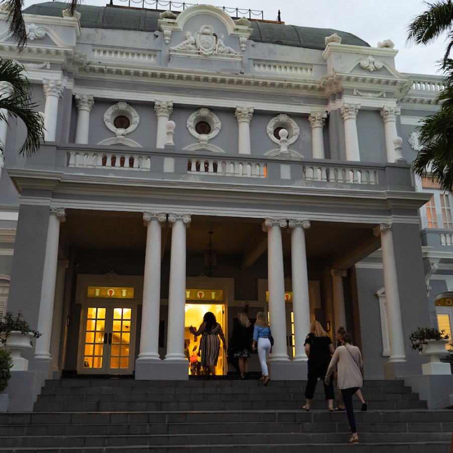 A group of people enter the Antiguo Casino of Puerto Rico for an event. 