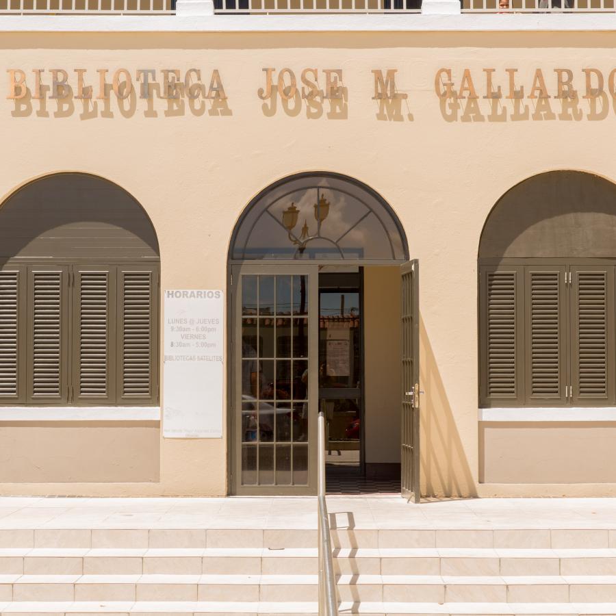 Front steps leading to the main door of Juncos' library, the entrance is framed by arc windows. 