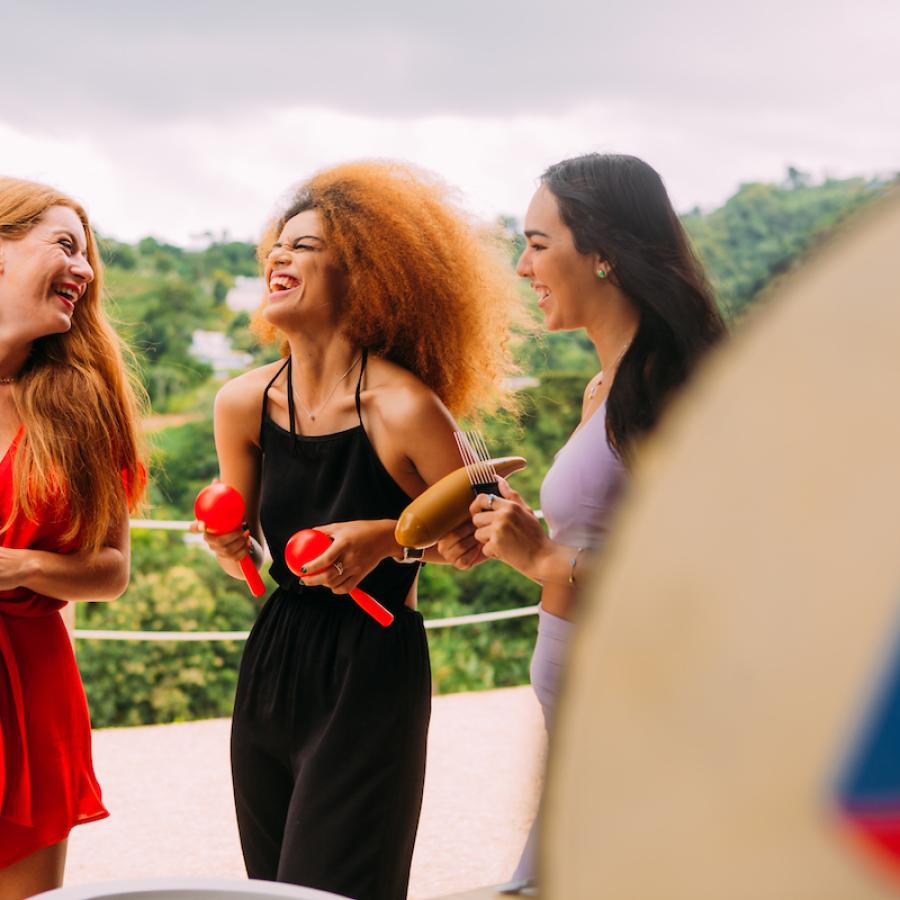 Girls are singing and laughing during a holiday parranda. 