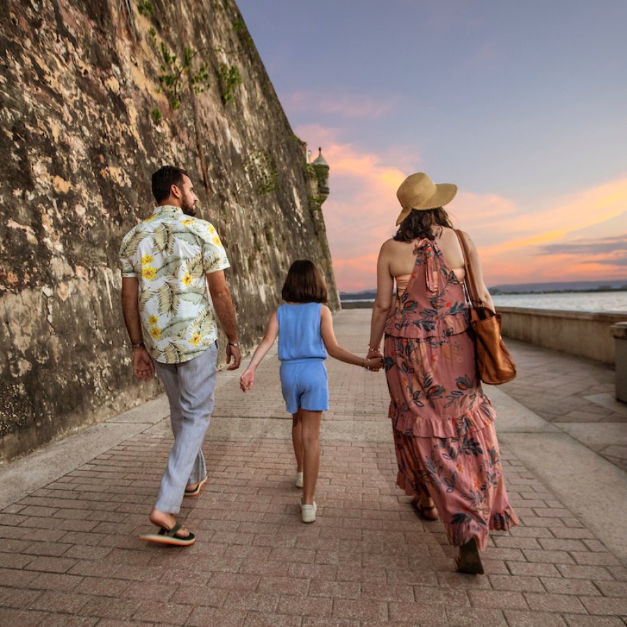 A family walks oceanside along the Paseo de la Princesa in Old San Juan.