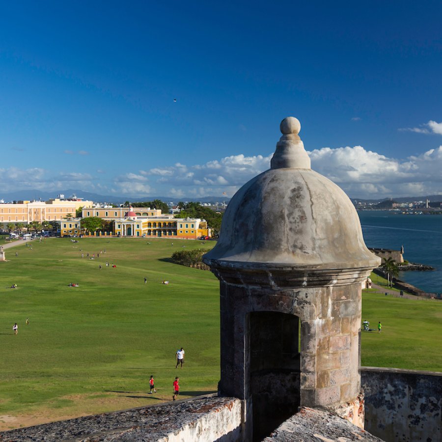 People approaching Castillo San Felipe del Morro in historic San Juan on a sunny day. 