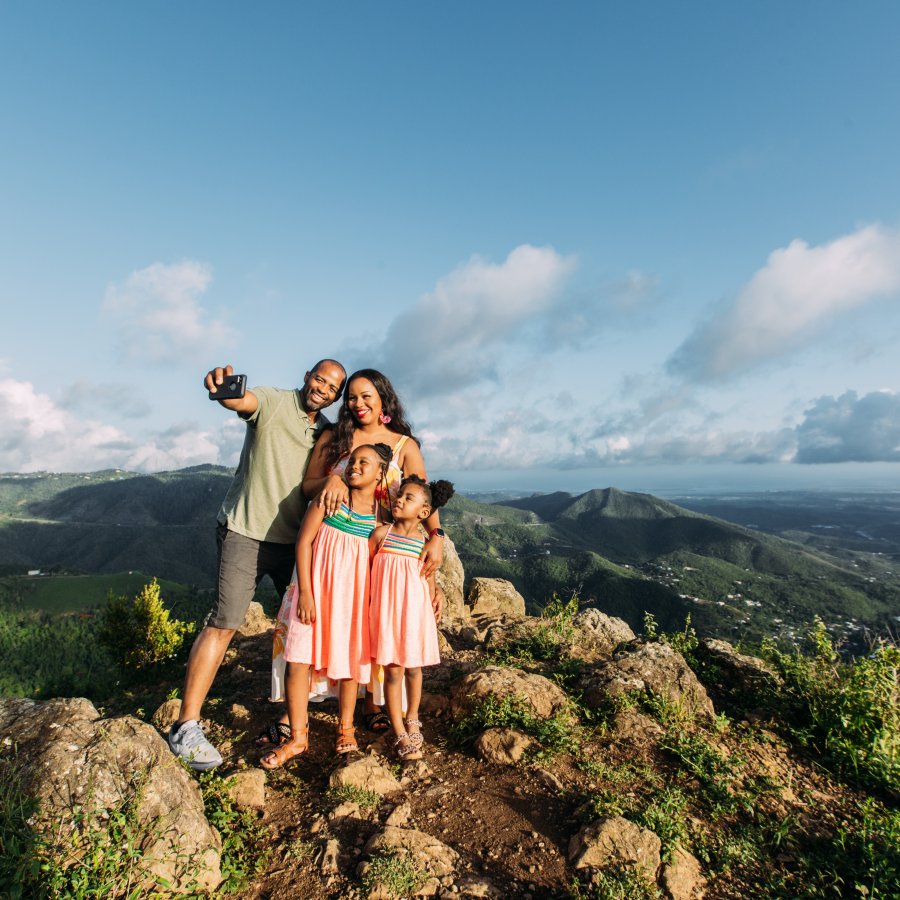 A family poses for a selfie during a hike. 