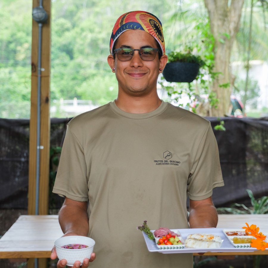 A chefs holds out a plate at Frutos del Guacabo